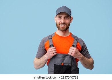 Portrait of smiling builder in uniform holding on his jumpsuit and looking at camera - Shutterstock ID 2157340711