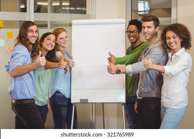 Portrait Of Smiling Business People Showing Thumbs Up White Standing By Whiteboard During Meeting In Office