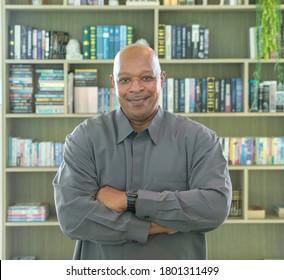 Portrait Of Smiling Business Senior Old Elderly Black Man, African American Person Working From Home And Talking To His Colleagues In Webcam Group Video Call Conference Online In Library .