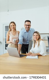 Portrait Of A Smiling Business Team, At Workplace, Looking At Camera.