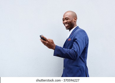 Portrait of a smiling businessman looking at cellphone 