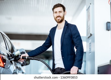 Portrait Of A Smiling Businessman Refueling His Luxury Car At The Gas Station