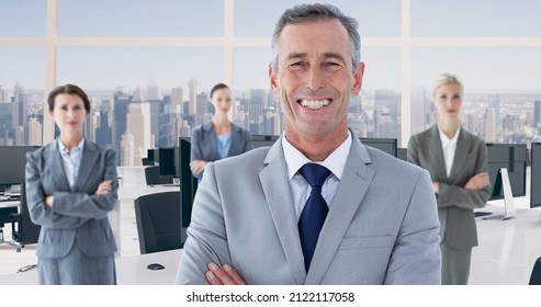 Portrait Of Smiling Businessman Standing Ahead Of Businesswomen At Modern Office. Business Mentorship And Teamwork.