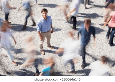 Portrait of smiling businessman surrounded by people rushing by