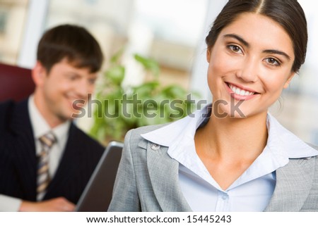 Portrait of smiling businesswoman on background of her working colleague
