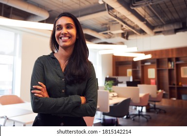 Portrait Of Smiling Businesswoman Standing In Modern Open Plan Office