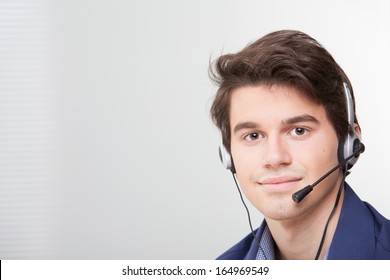 Portrait Of A Smiling Call Center Employee Wearing Headset