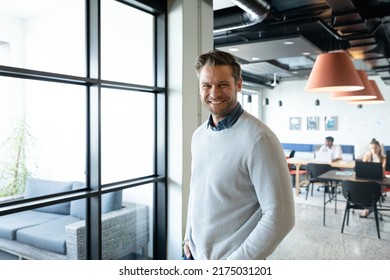 Portrait of smiling caucasian mid adult businessman in creative office. Unaltered, creative business, workplace, occupation, positive emotion. - Shutterstock ID 2175031201
