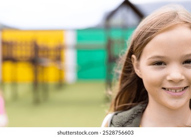 Portrait of smiling caucasian schoolgirl in schoolyard, with copy space. Education, inclusivity, elementary school and learning concept. - Powered by Shutterstock