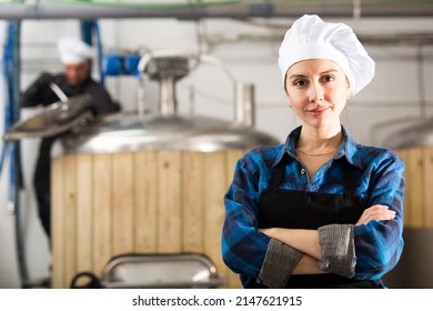 Portrait of smiling caucasian woman brewer in apron standing in workshop of beer factory. - Powered by Shutterstock