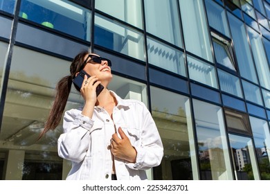Portrait of smiling caucasian woman with white teeth talking on phone, having pleasant conversation, hold mobile device. Perfect healthy smile with veneer. Dental care. 
 - Shutterstock ID 2253423701