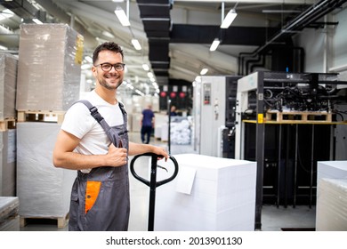 Portrait of smiling caucasian worker ready to put new sheets of paper into modern printing machine. - Shutterstock ID 2013901130