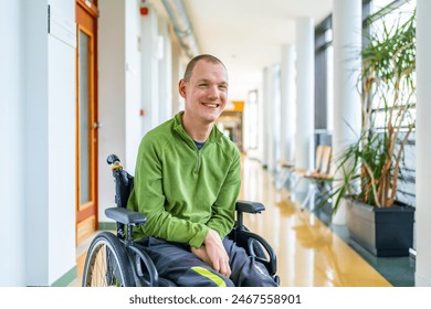 Portrait of a smiling caucasian young disabled man in wheelchair in the university - Powered by Shutterstock