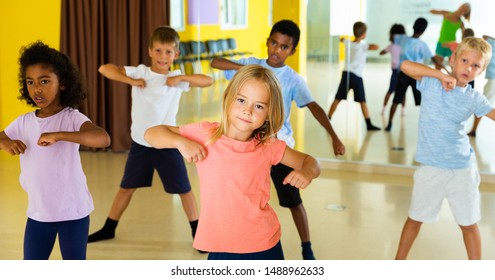 Portrait Of Smiling Children Practicing Sport Dance In Modern Dance Hall