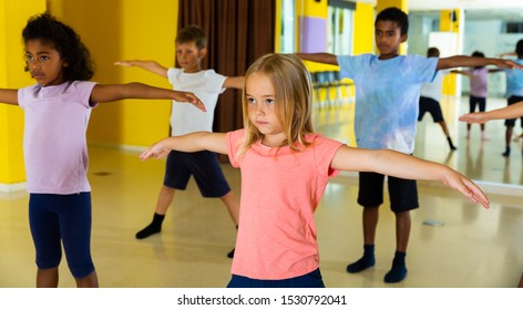 Portrait Of Smiling Children Practicing Sport Dance In Modern Dance Hall