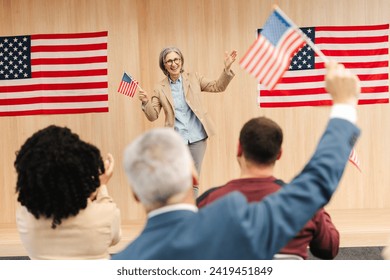 Portrait of smiling confident woman, politician, presidential candidate  holding American flag communication, speaking with audience. Vote, United States presidential election concept - Powered by Shutterstock