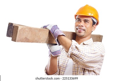 Portrait of a smiling construction worker carrying pieces of lumber. Isolated in white background.