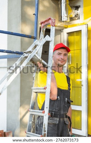 Portrait of smiling construction worker with stepladder near house, home repair and improvement, onsite builder service business, reliable expert.