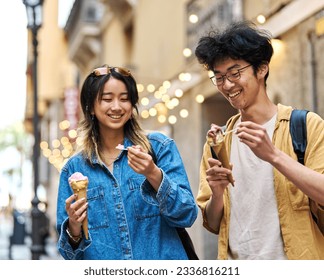 Portrait of a smiling couple in the city, tourists visiting destination, summer trip exploring and eating an ice cream - Powered by Shutterstock