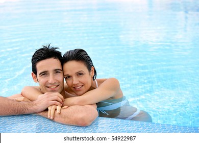 Portrait of a smiling couple leaning on a poolside - Powered by Shutterstock