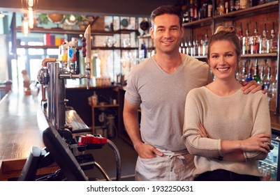 Portrait Of Smiling Couple Owning Bar Standing Behind Counter - Powered by Shutterstock