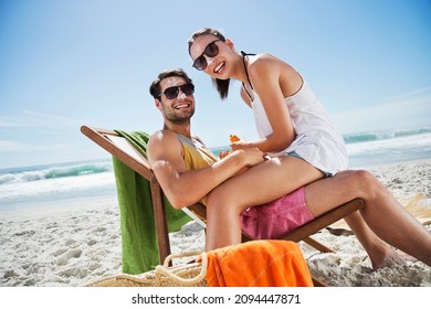 Portrait of smiling couple with sunscreen-covered noses at beach - Powered by Shutterstock