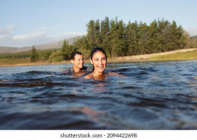 Portrait of smiling couple swimming in lake - Powered by Shutterstock