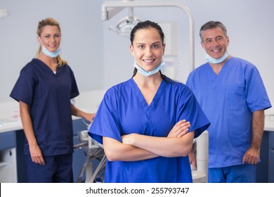 Portrait of smiling co-workers standing in dental clinic
