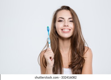 Portrait of a smiling cute woman holding toothbrush isolated on a white background