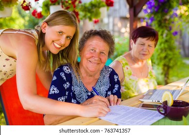 Portrait with smiling daughter while her elderly mother is signing succession testament for she.