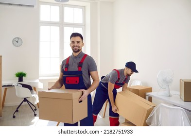 Portrait of smiling deliveryman in uniform hold cardboard box pack or unpack belongings in client home. Happy man mover workers from removal or delivery company. Relocation concept.