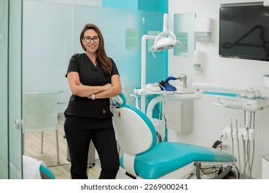 Portrait of a smiling dentist, standing in her dental surgery, with copy space. - Powered by Shutterstock