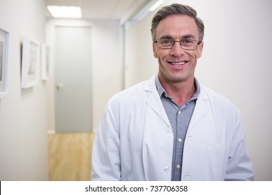 Portrait Of Smiling Dentist Standing At Lobby In Dental Clinic