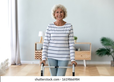 Portrait smiling disabled older woman standing with walker at home, rehabilitation and recovery after injure or accident, happy mature female looking at camera, healthcare and medical equipment