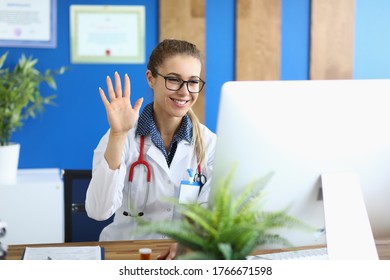 Portrait Of Smiling Doctor Greeting And Waving Hand. Practitioner Giving Online Consultation. Lady Looking At Computer With Gladness. Healthcare And Online Medicine Concept