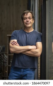 Portrait Of A Smiling Elderly Man 45-50 Years Old With A Strong Build, Perhaps He Is A Former Military Man Or A Loader, A Truck Driver Or A Charismatic Actor.