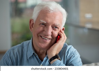 Portrait Of Smiling Elderly Man Using Mobile Phone