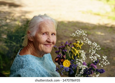 Portrait Of The Smiling Elderly Woman With Flowers, Mother Day