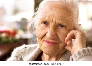 Portrait of the smiling elderly woman, sitting outdoor
