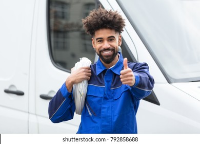 Portrait Of Smiling Electrician With White Cable Coil Standing By Van