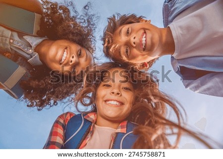 Portrait of smiling elementary middle school kids pupils classmates friends boys and girls standing in circle bonding forming a huddle in campus at school smiling with look at the camera