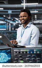 Portrait of smiling engineer in data center using artificial intelligence computerized model. Happy server room IT professional working with AI machine learning algorithms