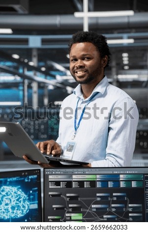 Portrait of smiling engineer in data center using artificial intelligence computerized model. Happy server room IT professional working with AI machine learning algorithms