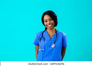 Portrait Of A Smiling Female Doctor Or Nurse Wearing Blue Scrubs Uniform And Stethoscope And Looking To Side, Isolated On Blue Background