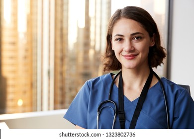 Portrait Of Smiling Female Doctor Wearing Scrubs With Stethoscope In Hospital Office