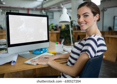 Portrait Of Smiling Female Graphic Designer Working On Computer In Creative Office