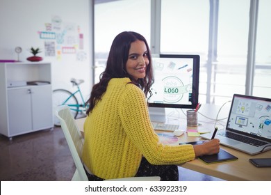 Portrait of smiling female graphic designer working in creative office