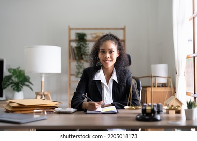 Portrait Smiling Female Lawyer Sitting At Workplace In Office