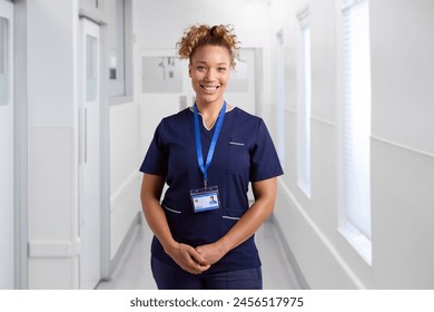 Portrait Of Smiling Female Nurse Wearing Uniform In Hospital Corridor With Security Lanyard - Powered by Shutterstock