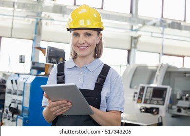 Portrait of smiling female worker using digital tablet in manufacturing industry